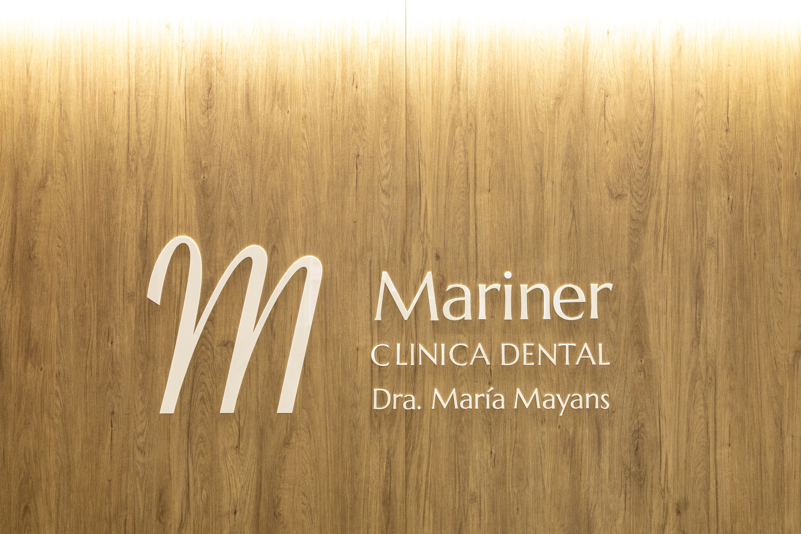 Diseño de logo dentista con una M grande acabado en blanco